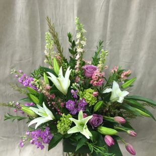 Simply Spring flower arrangement with delightful mix of Larkspur, Lilies, Roses, Stock, and Tulips