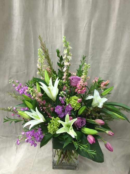 Simply Spring flower arrangement with delightful mix of Larkspur, Lilies, Roses, Stock, and Tulips