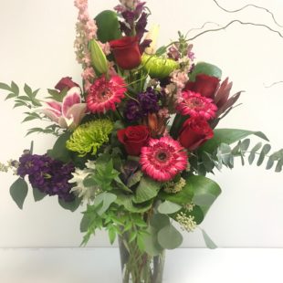 Wonderous Blooms flower arrangement with Gerbera Daisies, Pink Roses, red Roses, and spider mums